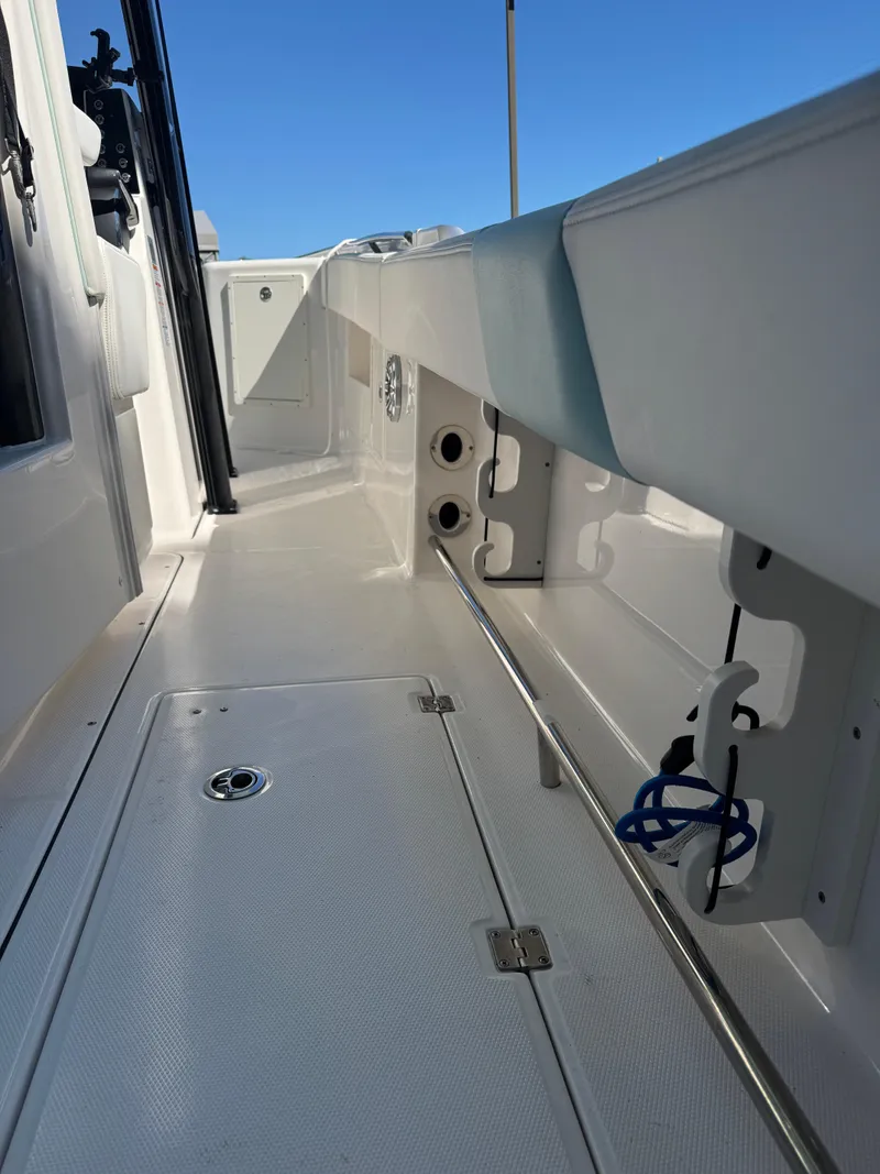 Slide: The Image of 2024 Robalo R302 Center Console boat deck with storage compartments. - 13