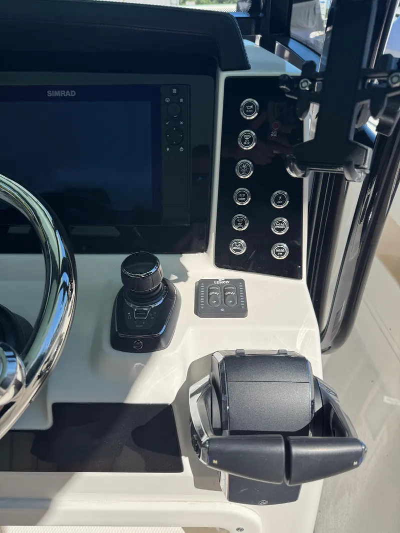 Slide: The Image of 2024 Robalo R302 Center Console boat dashboard with controls and display. - 19