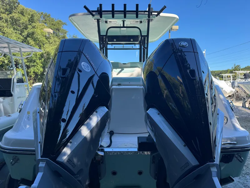 Slide: The Image of 2024 Robalo R302 Center Console with dual outboard engines, rear view. - 2