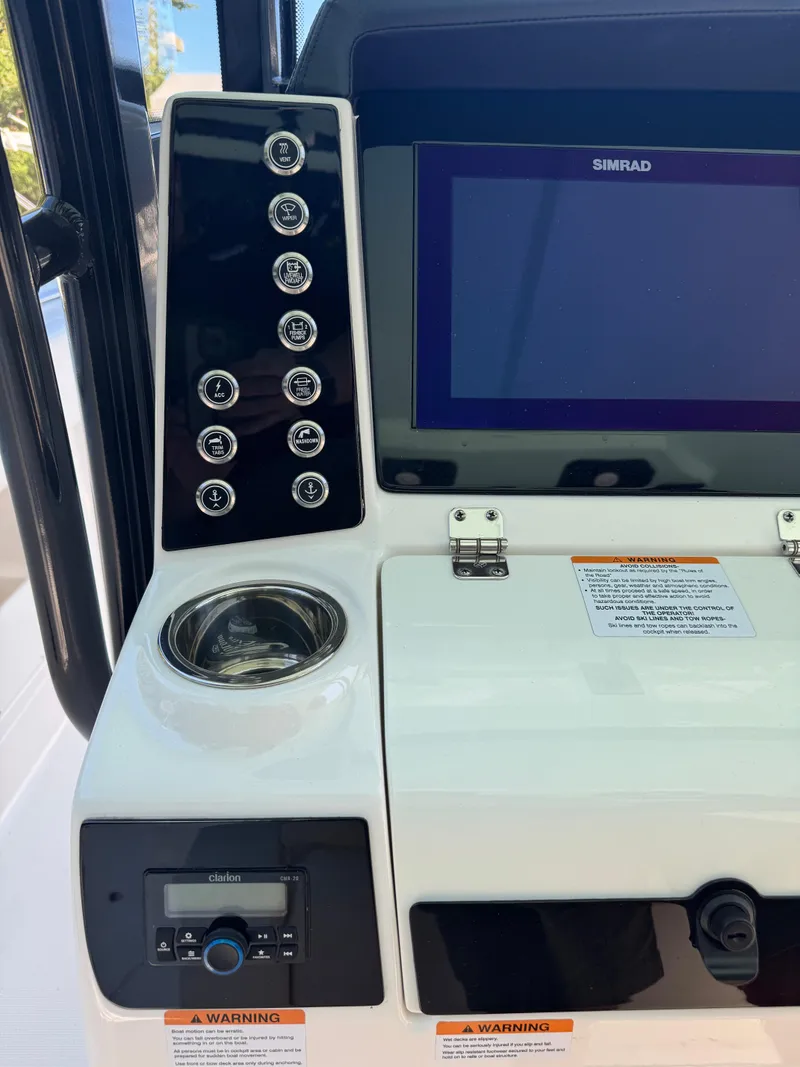 Slide: The Image of 2024 Robalo R302 Center Console dashboard with Simrad display and control panel. - 24