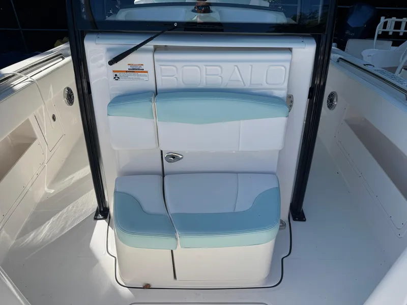 Slide: The Image of 2024 Robalo R302 Center Console boat seating area with white and blue cushions. - 31