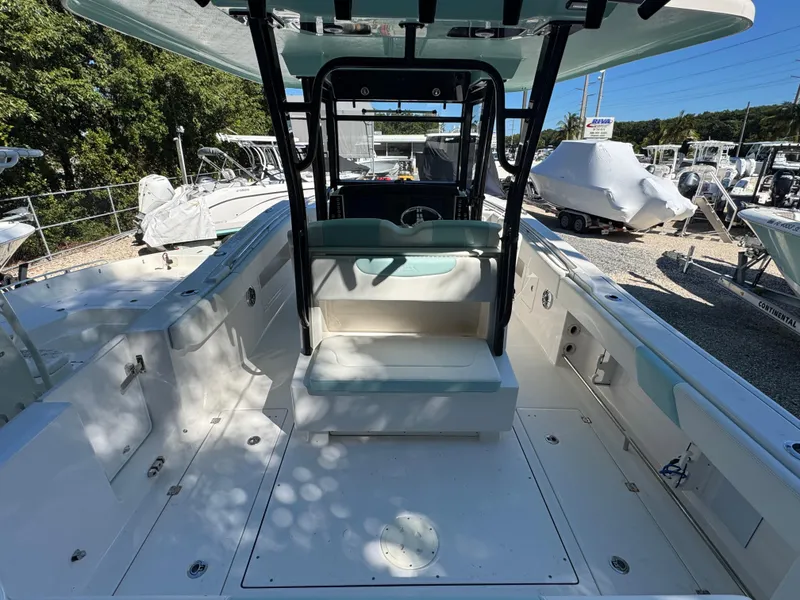 Slide: The Image of 2024 Robalo R302 Center Console boat interior with seating and console, docked outdoors. - 5