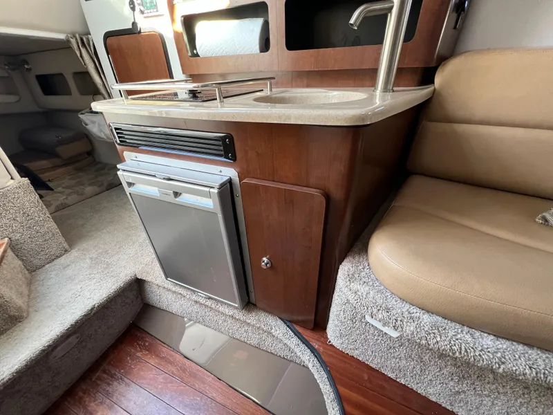 Slide: The Image of 2020 Crownline 264 CR boat interior with kitchenette, sink, and seating area. - 10