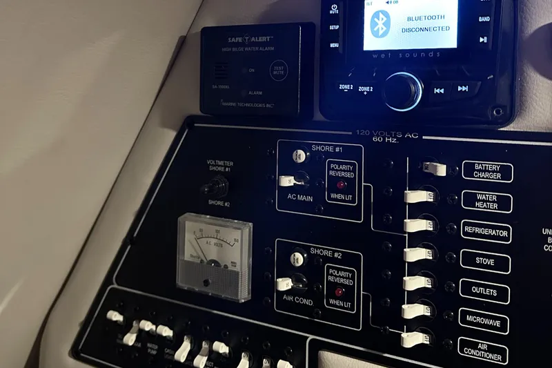 Slide: The Image of Control panel of a 2020 Crownline 264 CR boat with various switches and a Bluetooth device. - 11