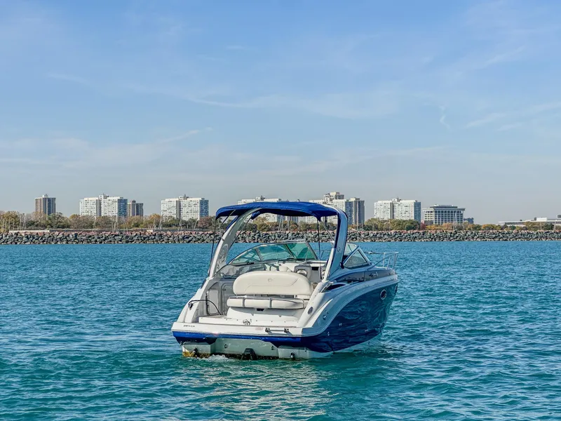 Slide: The Image of 2020 Crownline 264 CR boat on calm water with city skyline in background. - 5