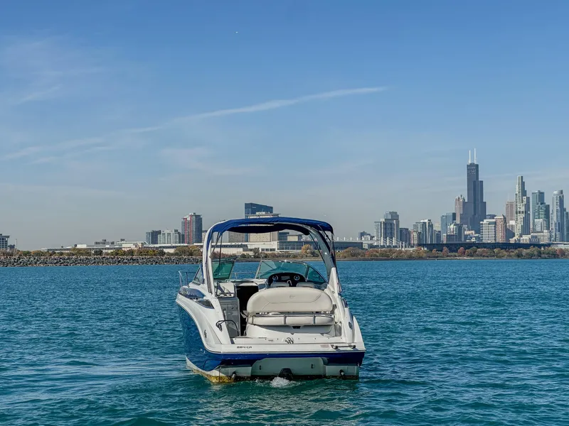 Slide: The Image of 2020 Crownline 264 CR boat on water with city skyline backdrop. - 6