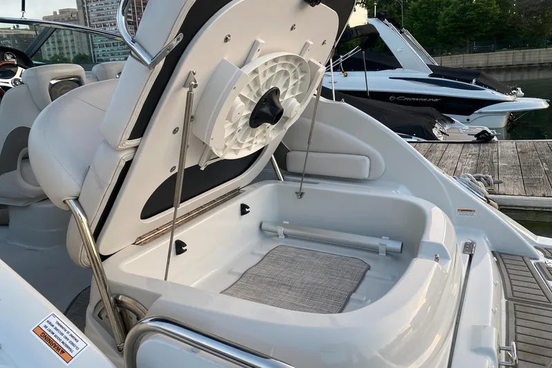 Slide: The Image of 2020 Crownline 264 CR boat with open storage compartment at marina dock. - 8