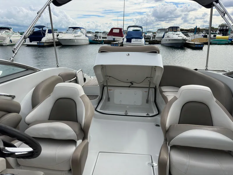 Slide: The Image of 2020 Crownline E235XS boat interior with open storage, docked at marina. - 11