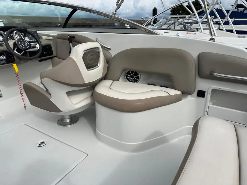 Slide: The Image of 2020 Crownline E235XS boat interior with beige seating and steering wheel. - 12