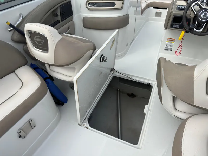 Slide: The Image of 2020 Crownline E235XS boat interior with open storage compartment and seating. - 14