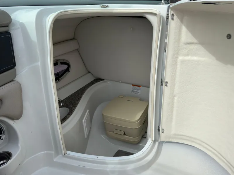Slide: The Image of 2020 Crownline E235XS boat interior with compact toilet compartment. - 17