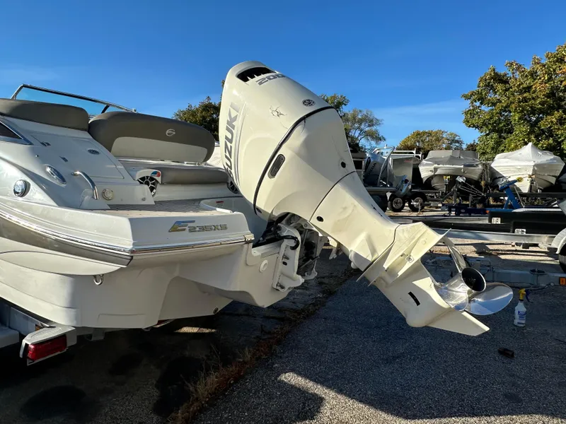 Slide: The Image of 2020 Crownline E235XS boat with outboard motor in a sunny outdoor setting. - 2