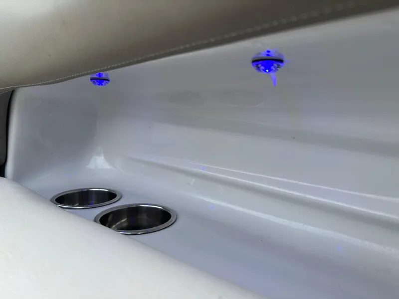 Slide: The Image of Interior of 2020 Crownline E235XS boat with cup holders and blue LED lights. - 23