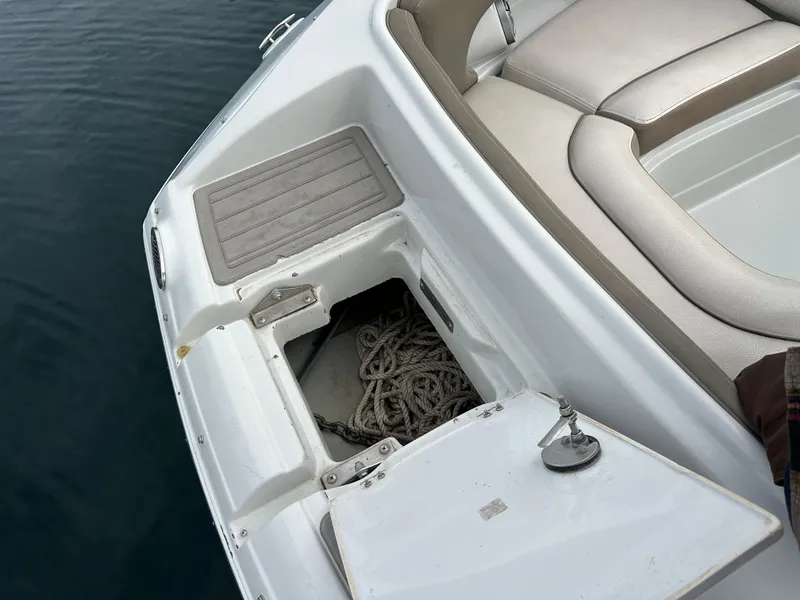 Slide: The Image of 2020 Crownline E235XS boat with open storage compartment and visible rope. - 25