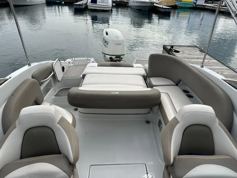 Slide: The Image of 2020 Crownline E235XS boat interior with seating, docked at marina. - 8