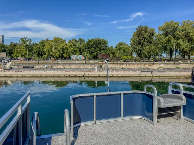 Slide: The Image of 2022 Avalon Catalina FunShip pontoon boat on calm water near a tree-lined shore. - 11
