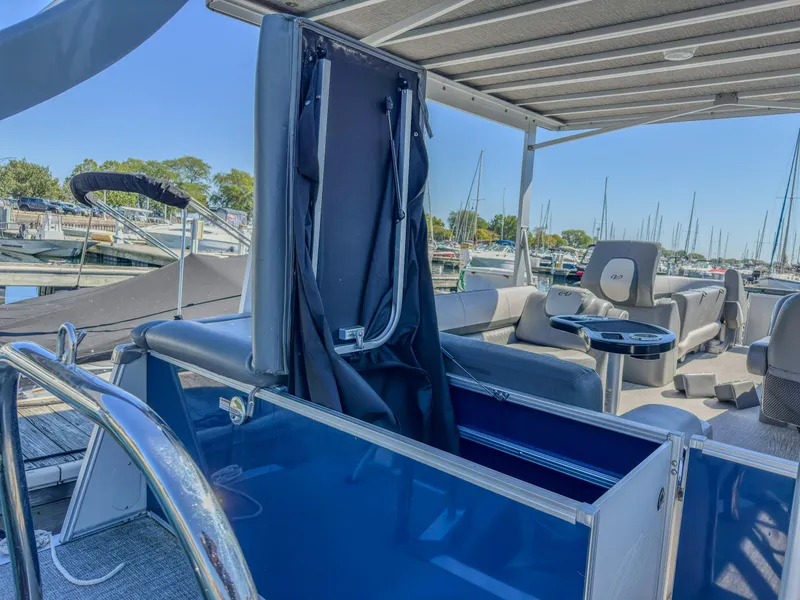 Slide: The Image of 2022 Avalon Catalina FunShip interior with seating and helm, docked at marina. - 12