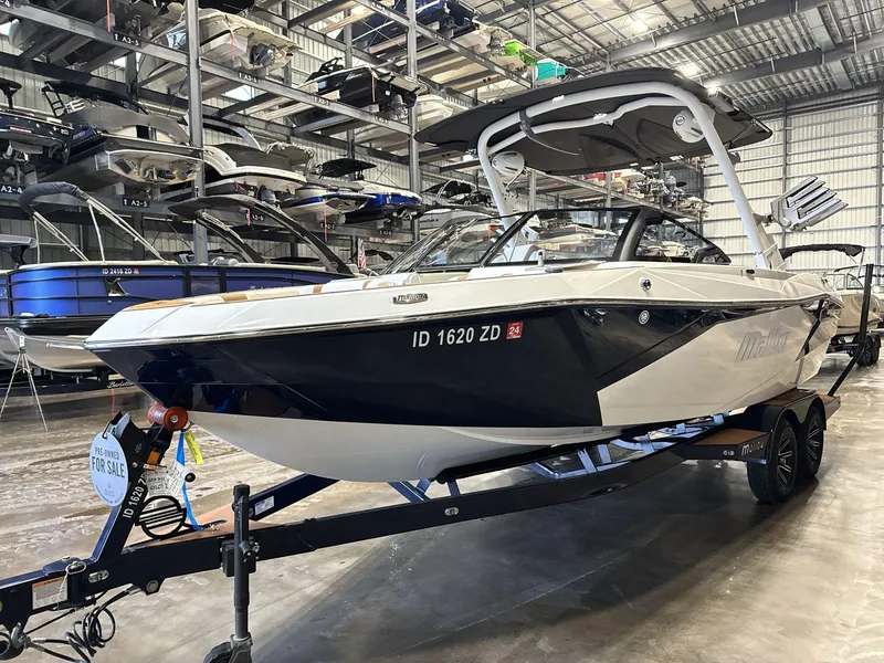 Slide: The Image of 2024 Malibu 23LSV boat on trailer in storage facility, available for sale. - 3