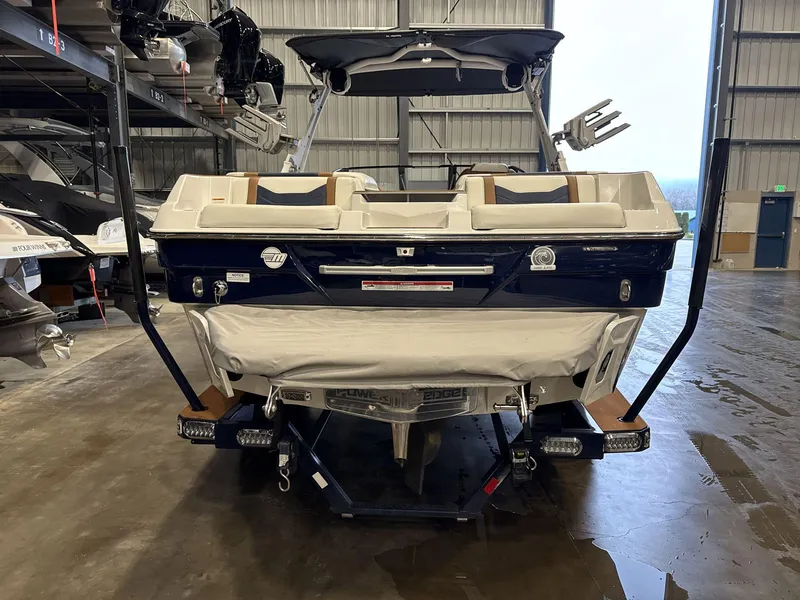 Slide: The Image of 2024 Malibu 23LSV boat in a warehouse, rear view, showcasing sleek design and features. - 5