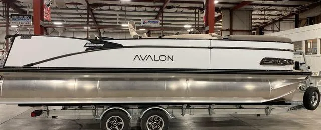 Slide: The Image of 2025 Avalon 23 Catalina Versatile Rear Bench pontoon boat in a showroom. - 1