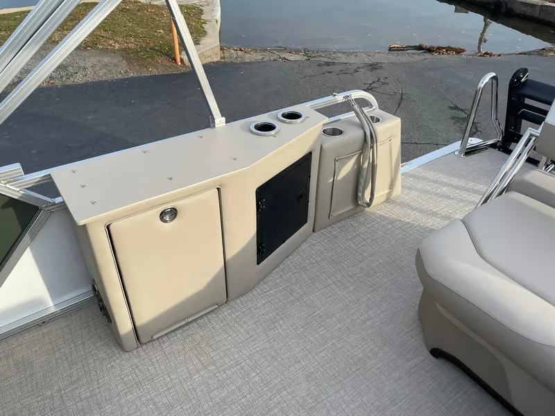 Slide: The Image of 2025 Avalon LSZ Cruise Rear Bench with storage and cup holders on a boat deck. - 17