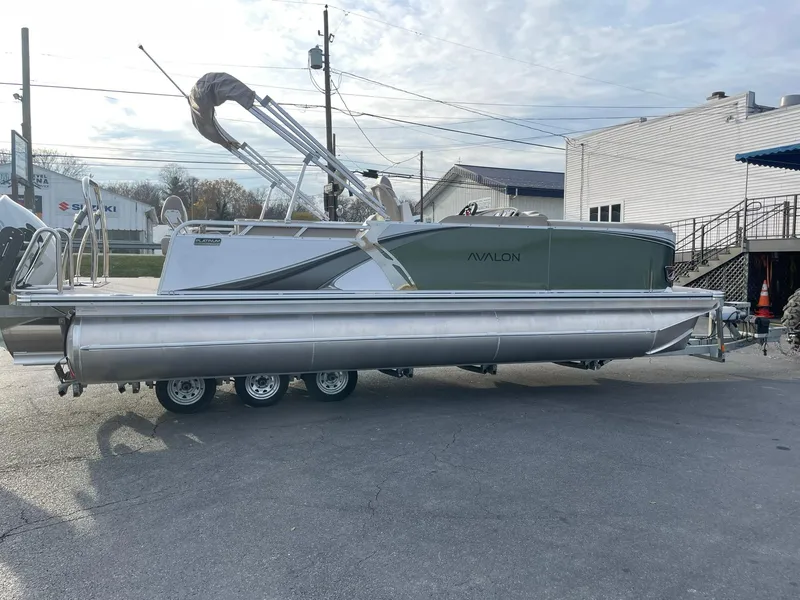 Slide: The Image of 2025 Avalon LSZ Cruise Rear Bench pontoon boat in a parking lot. - 6