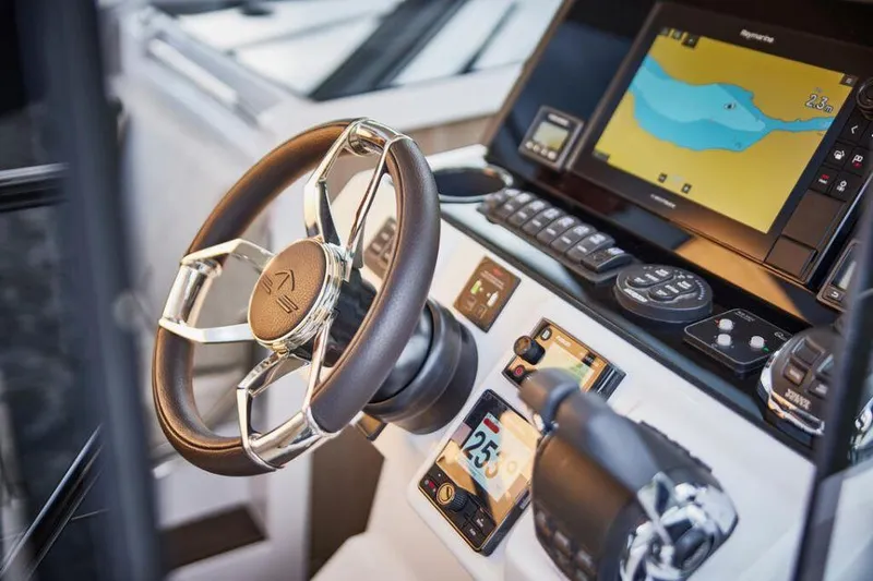 Slide: The Image of 2025 Sealine C335V yacht cockpit with modern steering wheel and navigation system. - 10
