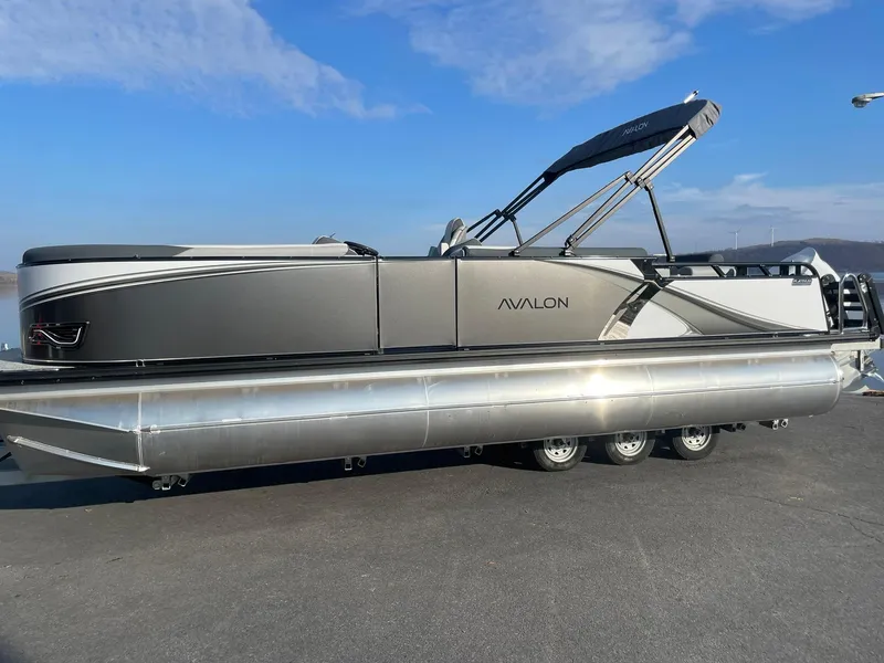 Slide: The Image of 2025 Avalon LSZ ELITE pontoon boat with sleek design on a sunny day. - 1