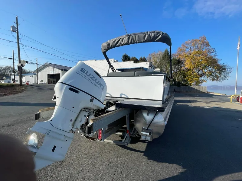 Slide: The Image of 2025 Avalon LSZ ELITE pontoon boat with Suzuki outboard motor on a sunny day. - 6