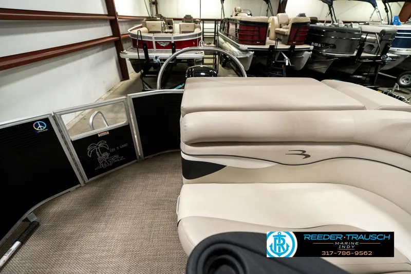 Slide: The Image of 2019 Bennington 21 SLX pontoon boat interior with beige seating in showroom. - 15