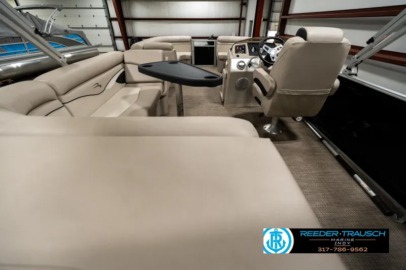 Slide: The Image of 2019 Bennington 21 SLX pontoon boat interior with beige seating and steering console. - 16