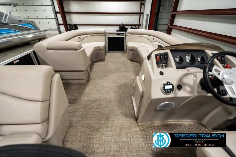 Slide: The Image of 2019 Bennington 21 SLX pontoon boat interior with beige seating and modern dashboard. - 17