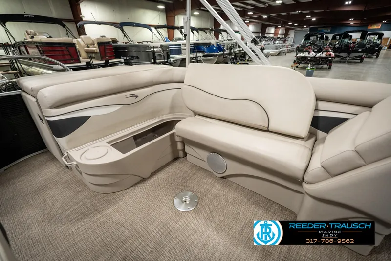 Slide: The Image of 2019 Bennington 21 SLX pontoon boat interior with beige seating and storage compartments. - 25