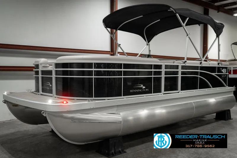 Slide: The Image of 2019 Bennington 21 SLX pontoon boat with black canopy in showroom. - 3