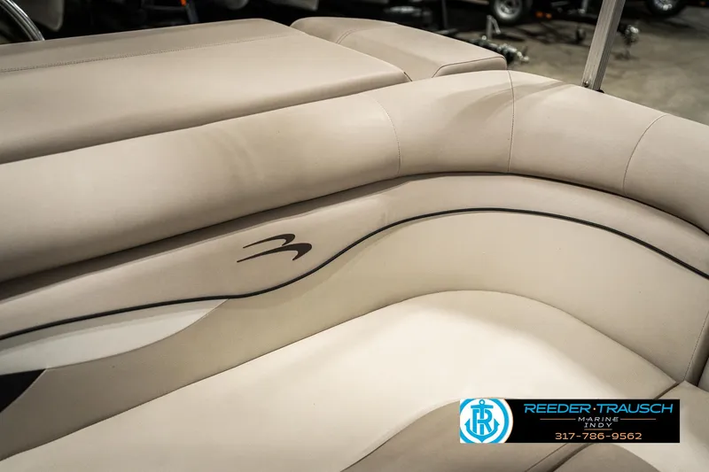 Slide: The Image of 2019 Bennington 21 SLX boat interior with beige seating and logo detail. - 39