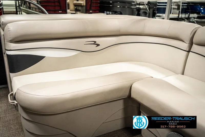 Slide: The Image of 2019 Bennington 21 SLX boat interior with beige seating, Reeder-Trausch Marine logo visible. - 40
