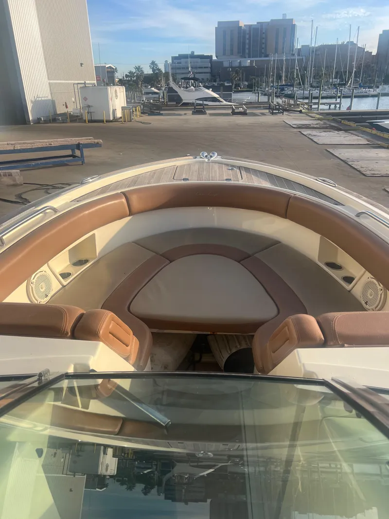 Slide: The Image of 2017 Chris-Craft Calypso boat with tan seating at a marina. - 16