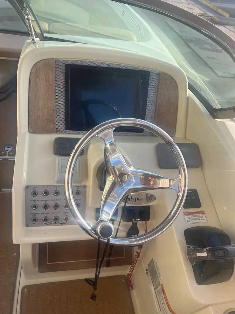 Slide: The Image of 2017 Chris-Craft Calypso boat dashboard with steering wheel and control panel. - 7