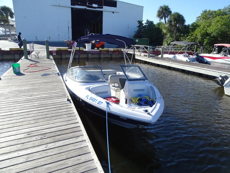 Slide: The Image of 2021 Regal 1900 ES Bowrider docked at marina with canopy. - 12