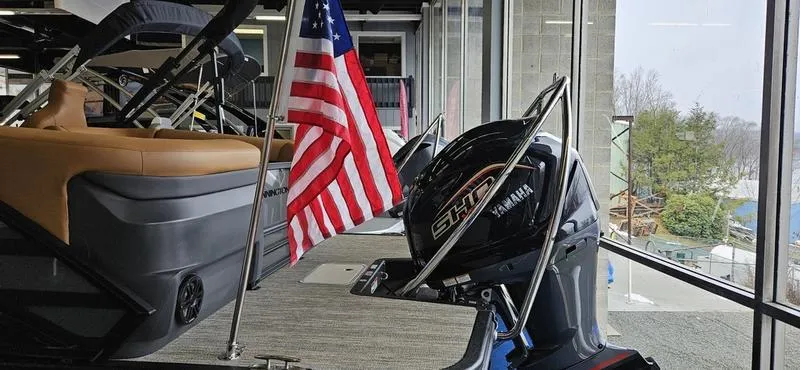 Slide: The Image of 2025 Bennington 24 MFB boat with Yamaha engine and American flag display. - 13