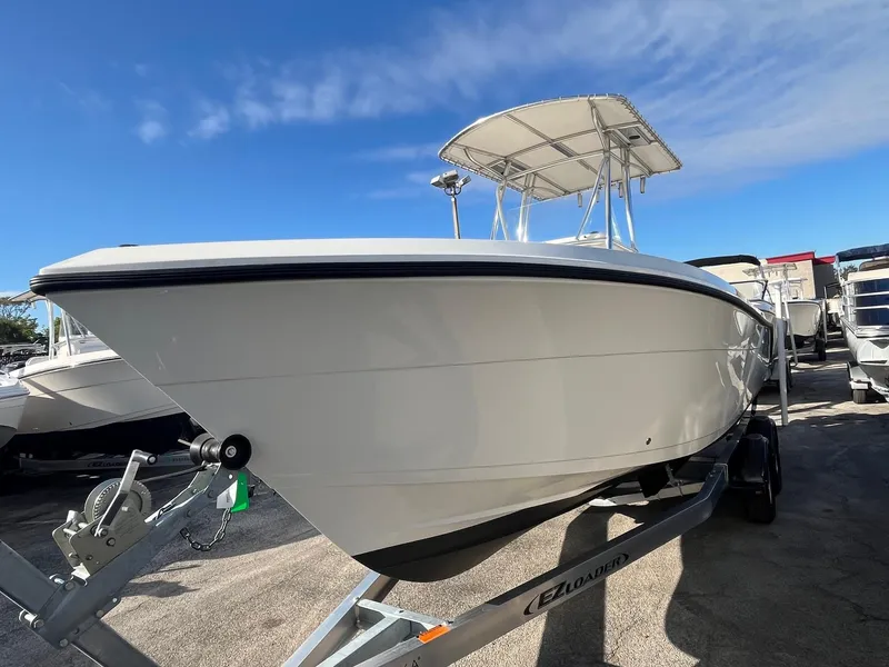 Slide: The Image of 2022 Cobia 237 Center Console boat on trailer under clear blue sky. - 2