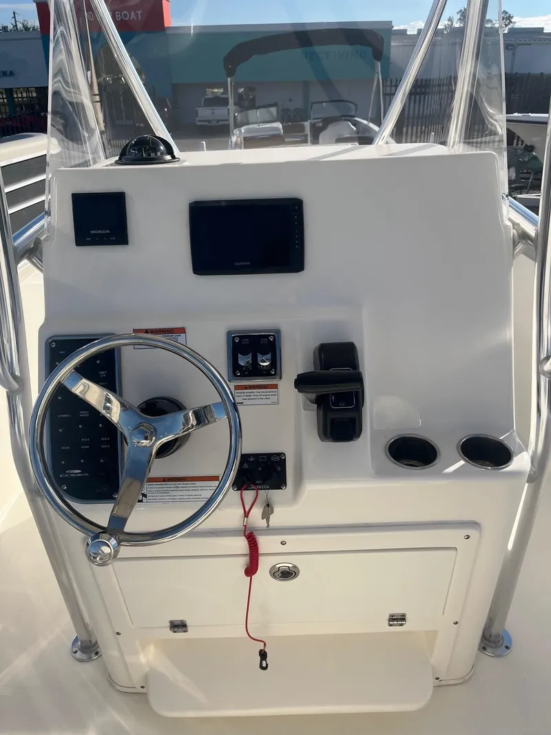 Slide: The Image of 2022 Cobia 237 Center Console boat dashboard with steering wheel and controls. - 4