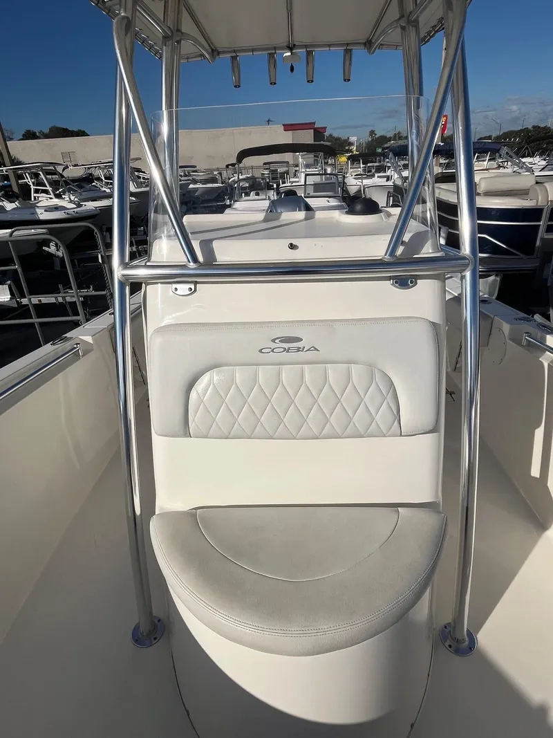 Slide: The Image of 2022 Cobia 237 Center Console boat with cushioned seating and stainless steel frame. - 6