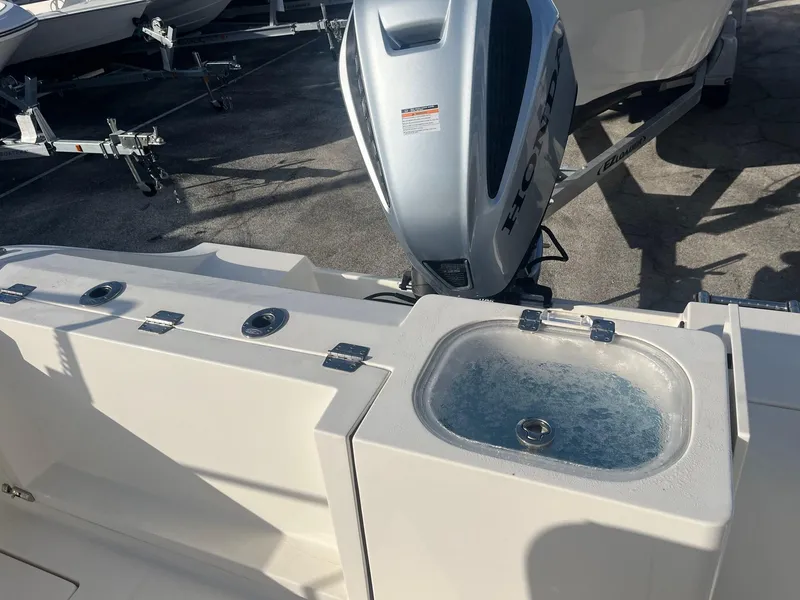 Slide: The Image of 2022 Cobia 237 Center Console boat with Honda outboard motor and livewell. - 8