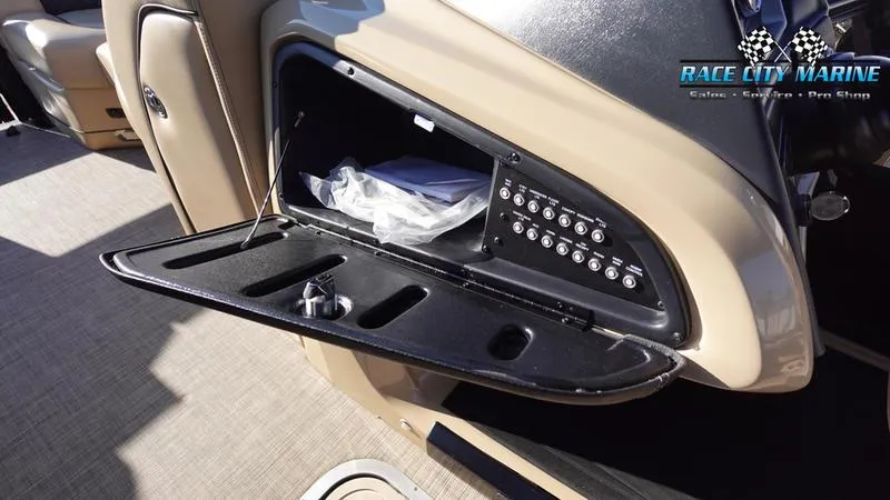 Slide: The Image of 2020 Barletta L23UC boat dashboard with open storage compartment and control panel. - 25