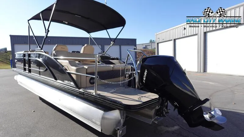 Slide: The Image of 2020 Barletta L23UC pontoon boat with canopy and outboard motor in a marina setting. - 7