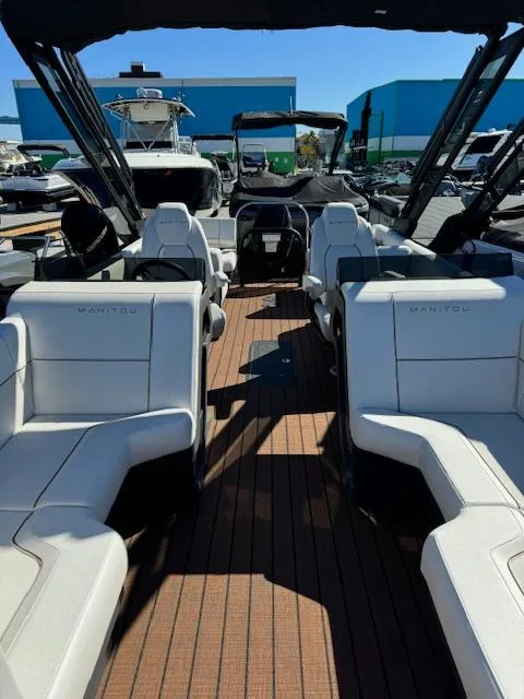 Slide: The Image of 2025 Manitou 22' Explore Navigator boat interior with white seating and modern design. - 2