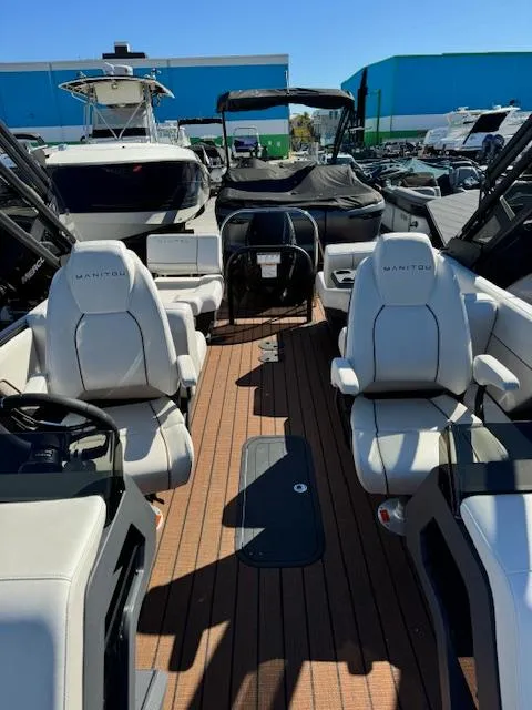 Slide: The Image of 2025 Manitou 22' Explore Navigator boat interior with modern seating and sleek design. - 6