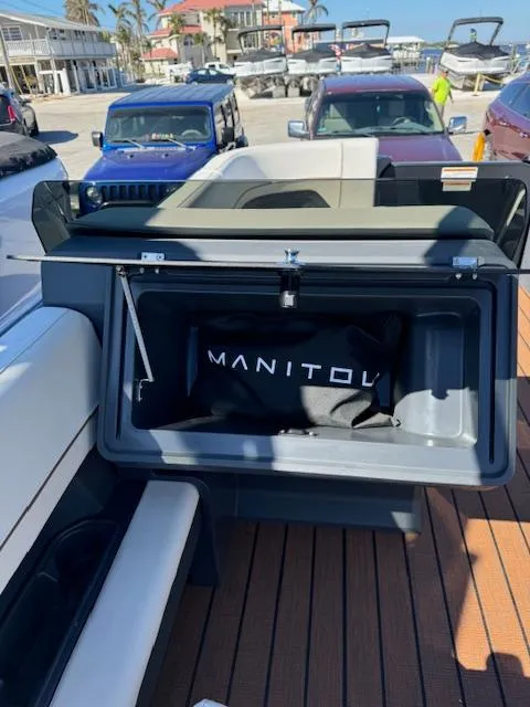 Slide: The Image of 2025 Manitou 22' Explore Navigator boat with open storage compartment. - 9
