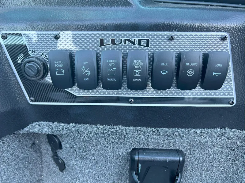 Slide: The Image of Control panel of 2025 Lund 1875 Impact XS boat with various switches. - 5